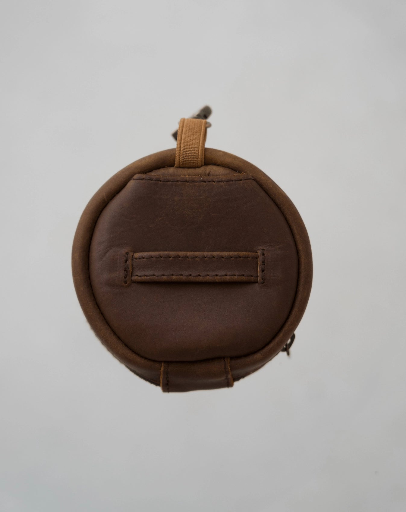 Back of Mandrn leather rover circle pouch in color saddle