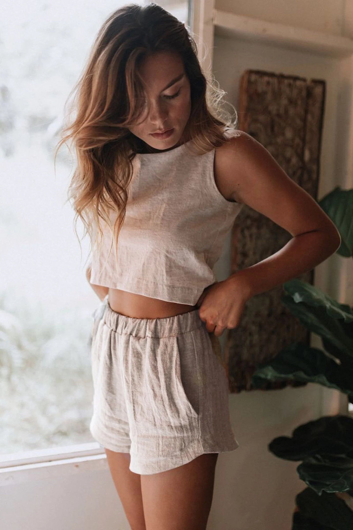 Woman wearing kepola design house Delphi linen shorts in oyster and Naples linen crop tank in oyster