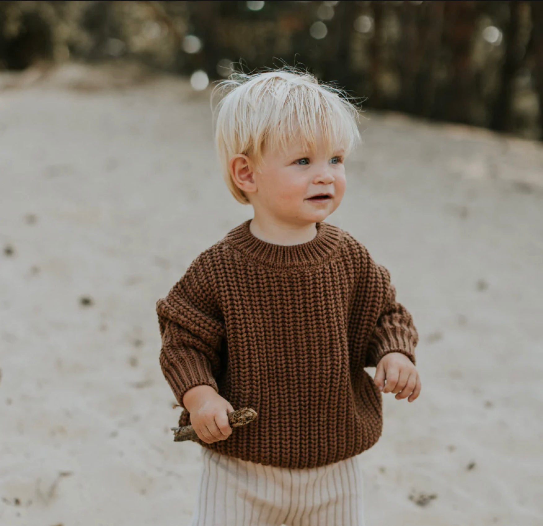 Baby wearing Yuki 100% organic cotton baby or child chunky knit sweater in color walnut
