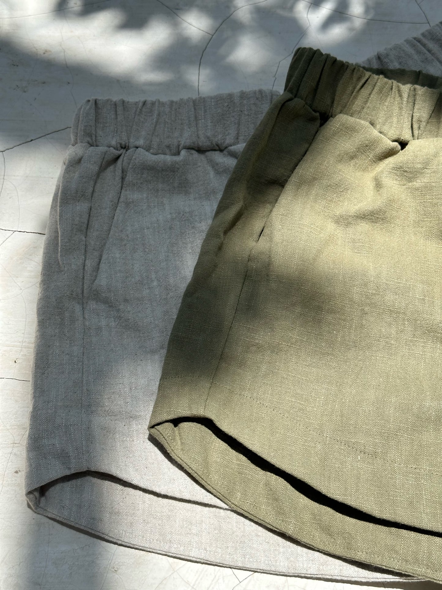 Close up of kepola design house Delphi linen shorts in oyster and artichoke