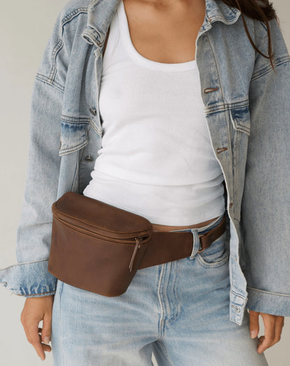 Model wearing mandrn remy fanny pack belt bag  in saddle color
